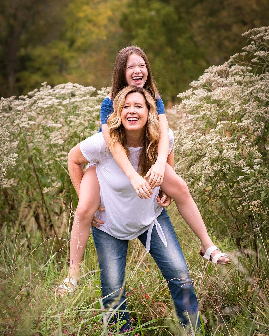 Mother and daughter in a field with tall grasses.
