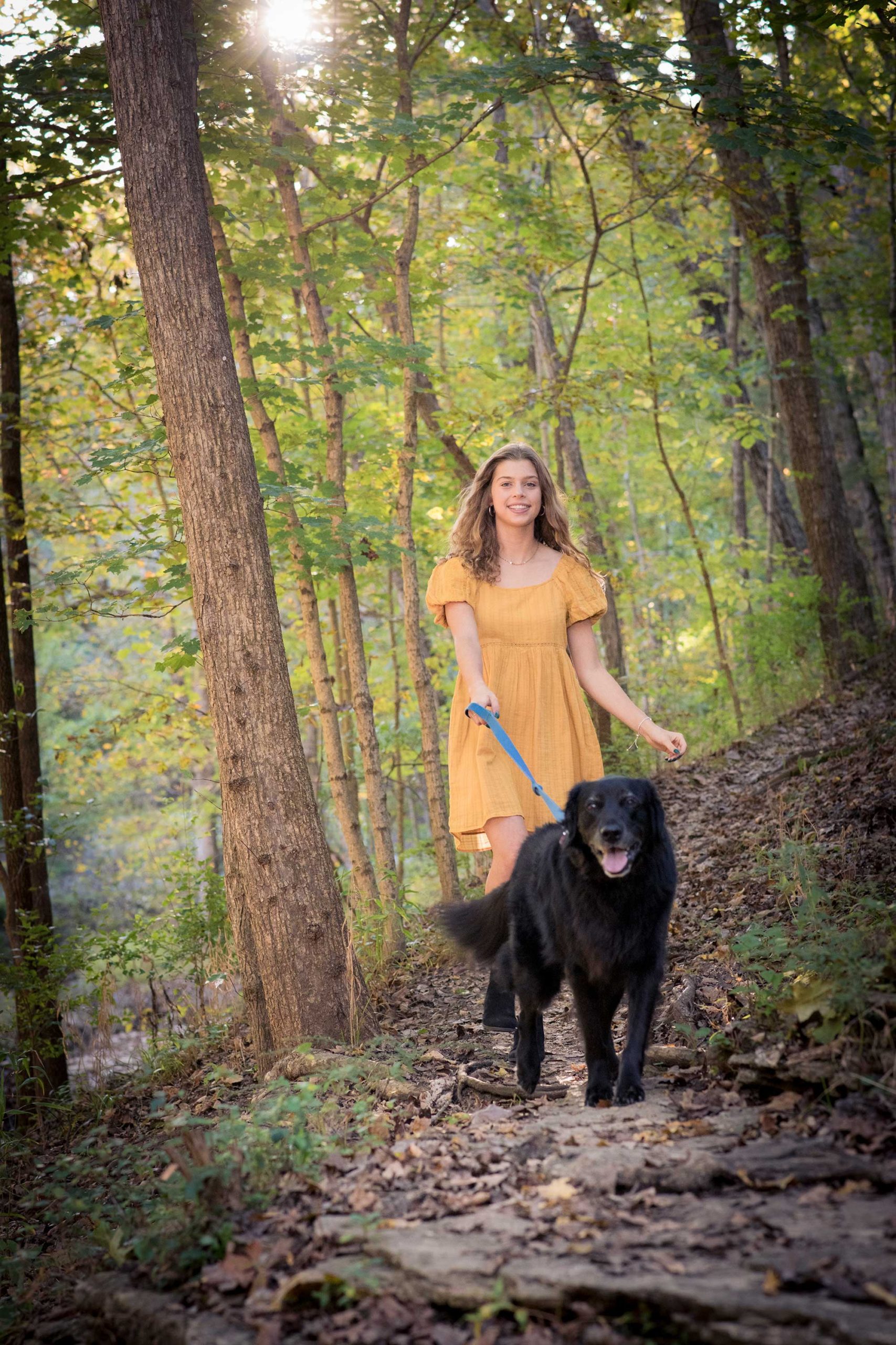 Senior Girl in Woods with dog during Autumn.