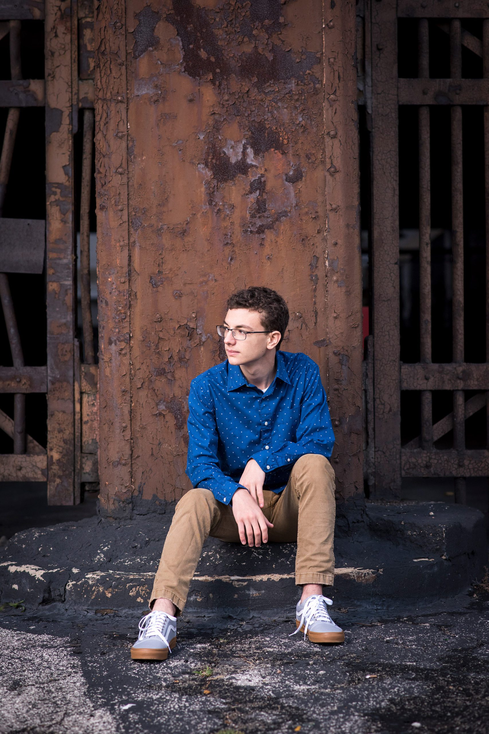 Senior Boy on loading dock of rusted building.