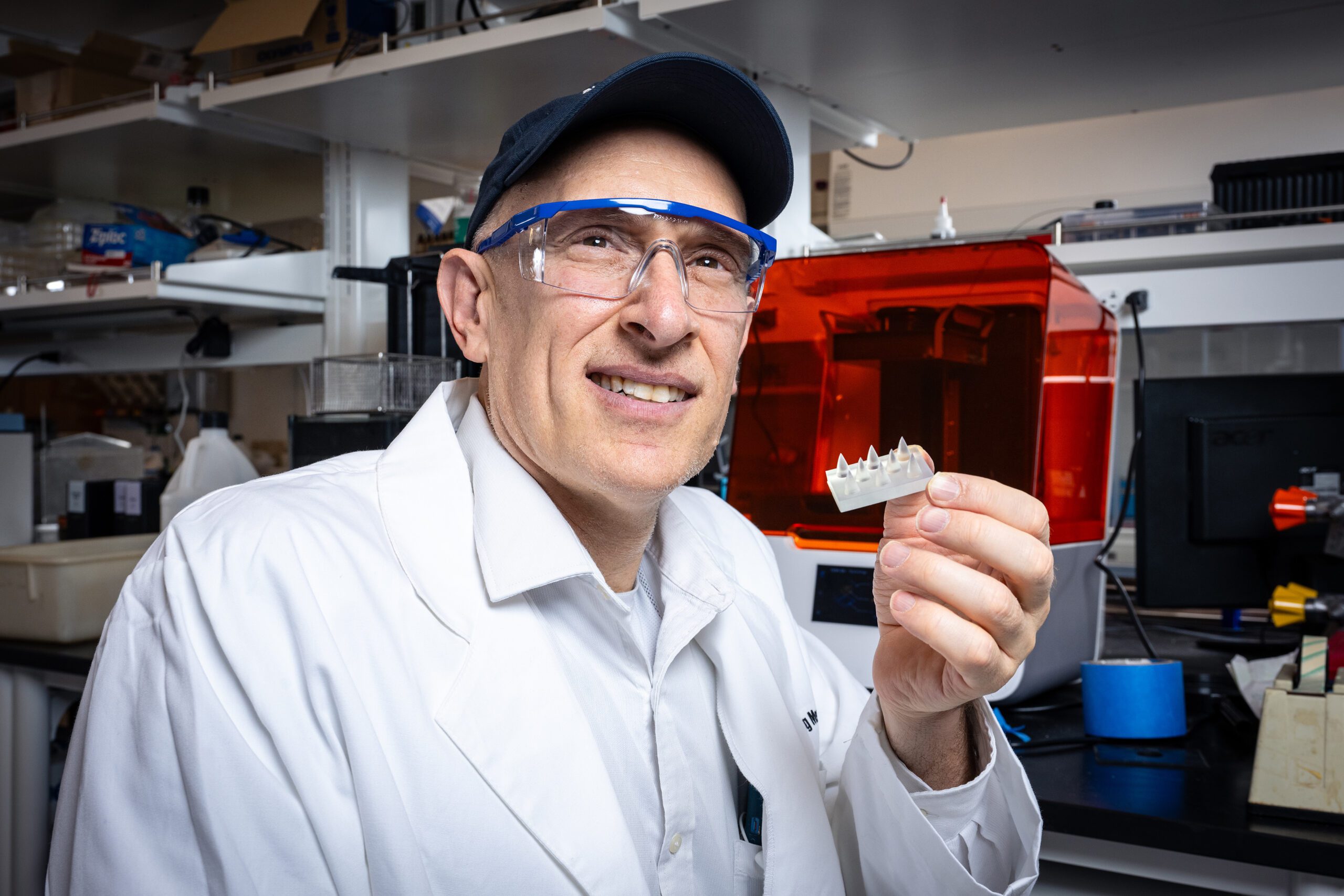 Engineering Professor with jaw toothed device in lab.